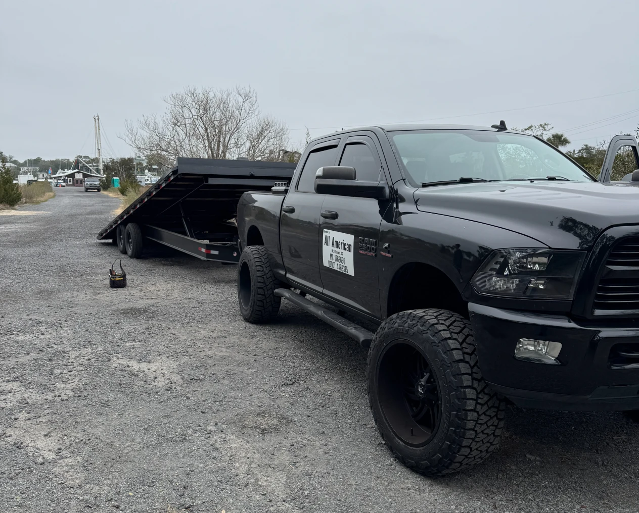 Black pickup parked with attached trailer.