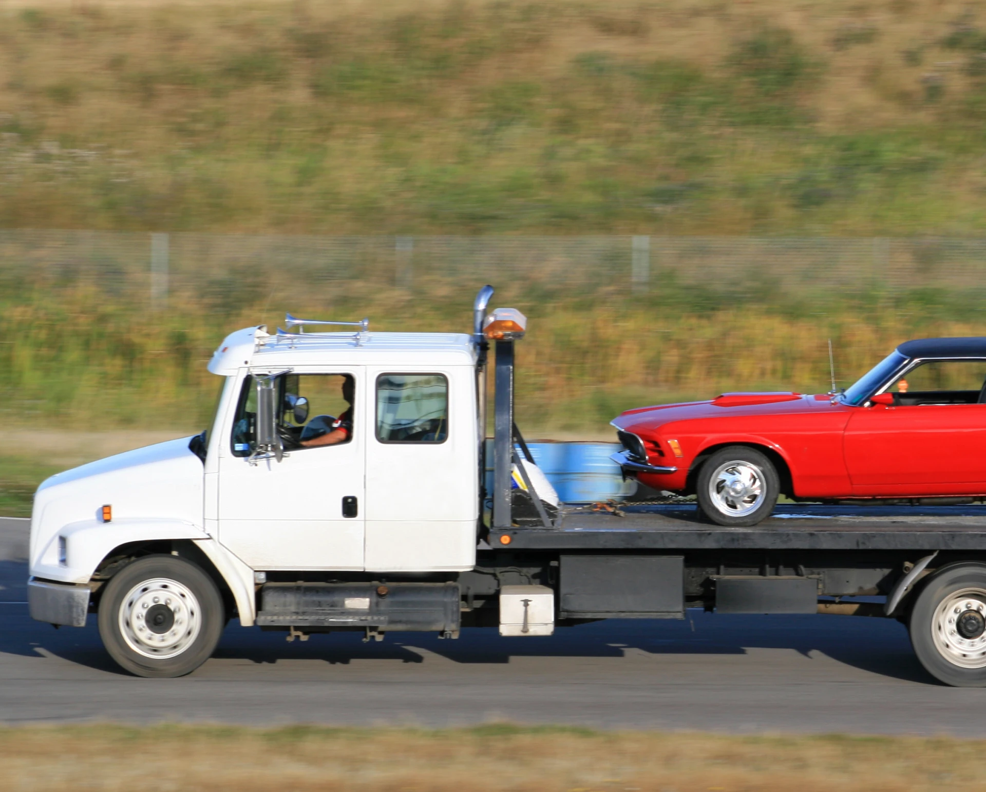 Flatbed truck with vintage red car